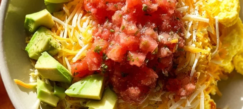 Delicious breakfast burrito bowl with eggs, vegetables, and salsa.
