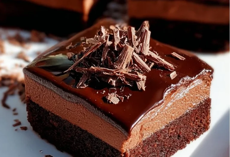 Delicious chocolate mousse brownies served on a plate, topped with chocolate flakes.