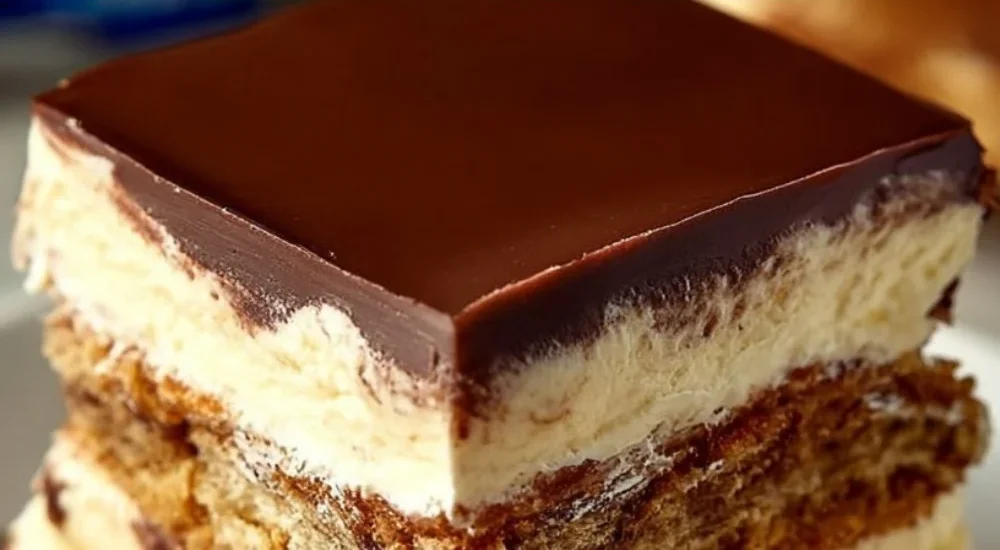 No-bake chocolate eclair cake topped with creamy chocolate icing