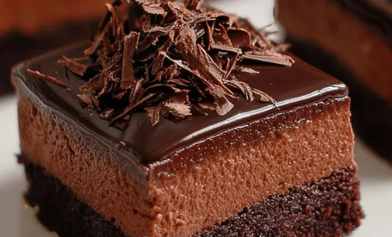 Delicious chocolate mousse brownies topped with whipped cream and cocoa powder